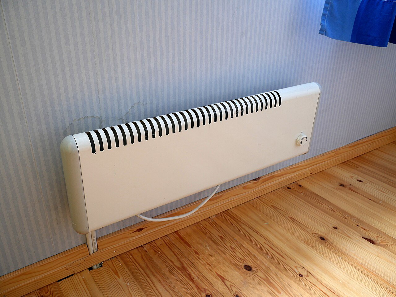 Radiateur électrique blanc fixé au mur dans un logement